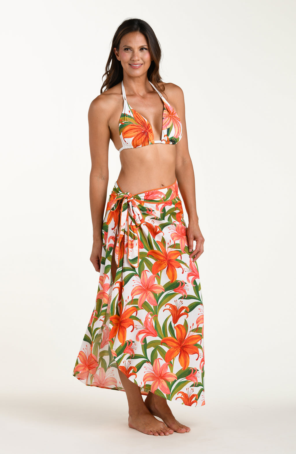 Woman wearing a matching floral swimsuit top and skirt on a white background