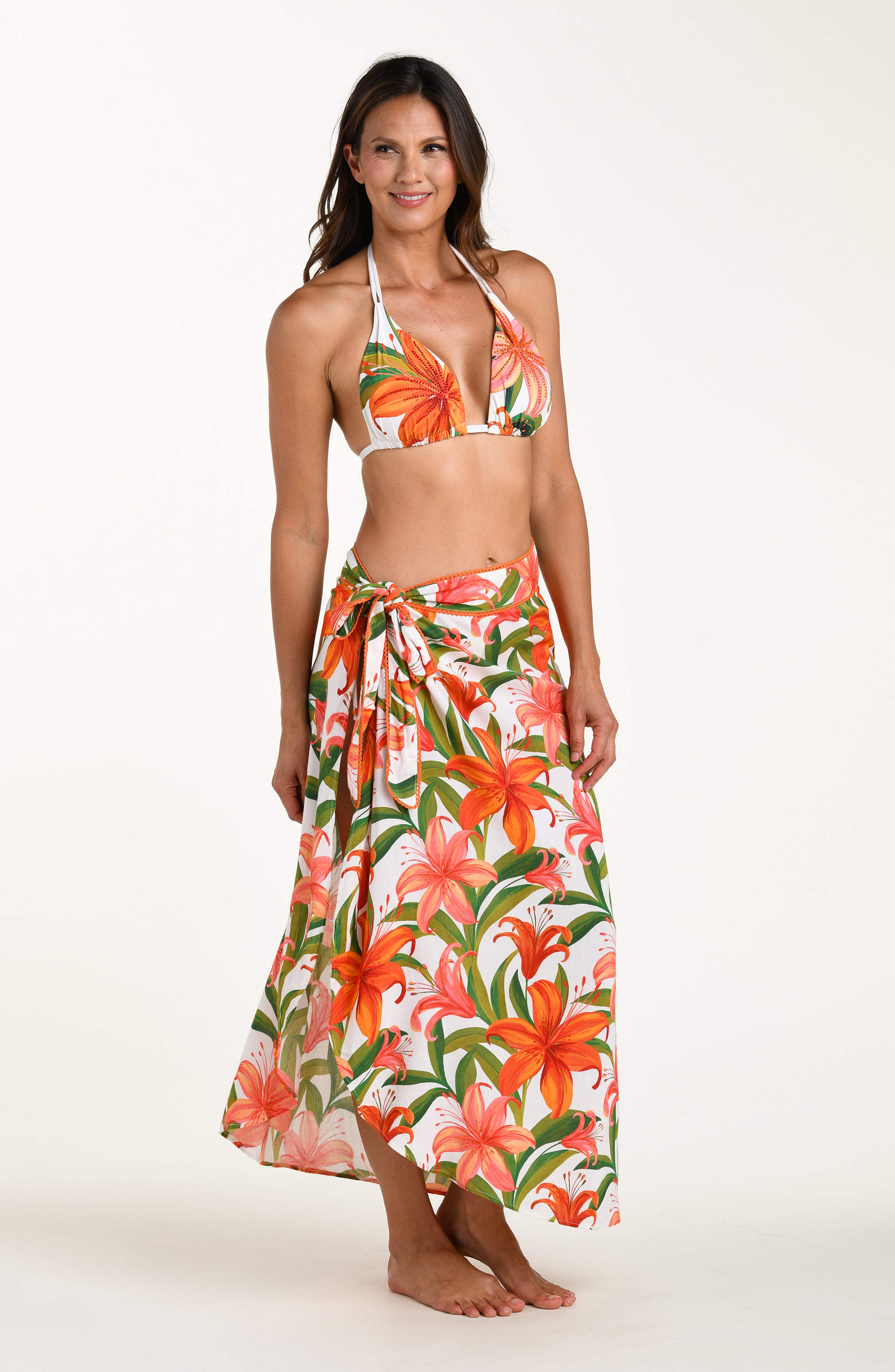 Woman wearing a matching floral swimsuit top and skirt on a white background