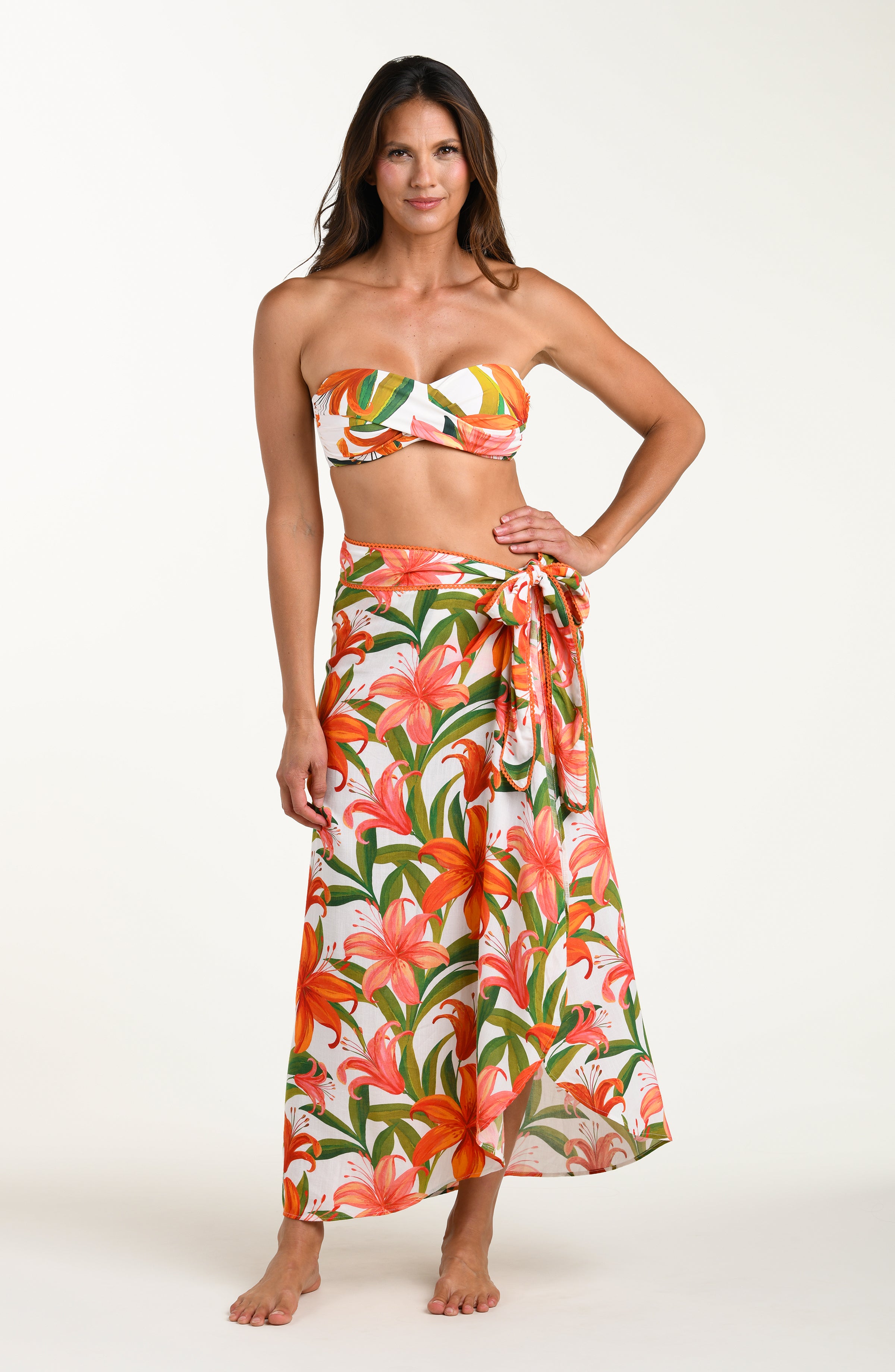 Woman wearing a matching floral swimsuit top and skirt on a white background
