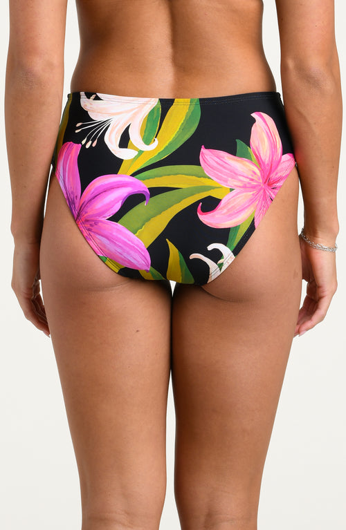 Woman wearing a floral bikini bottom against a white background 