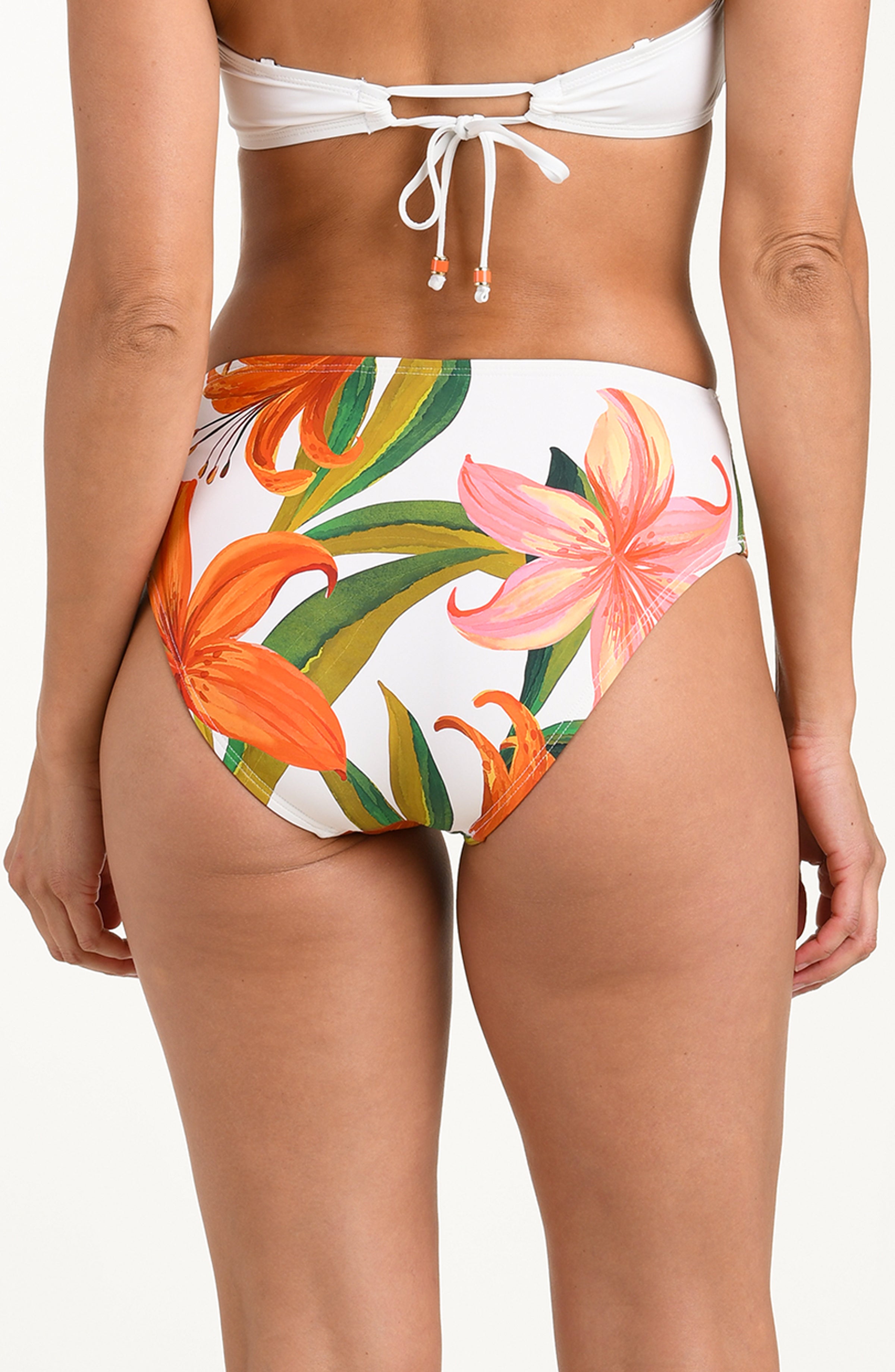 Woman wearing a floral swimsuit bottom on a white background