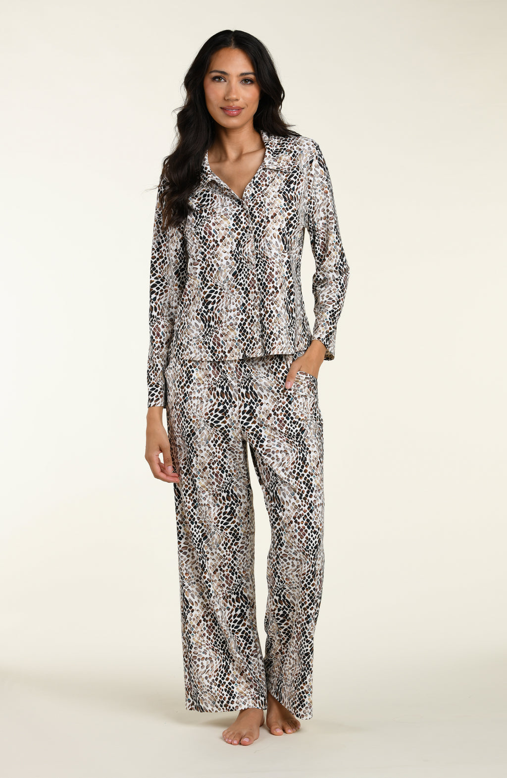 Woman wearing a snake print long sleeves and pants pajama set against a white background