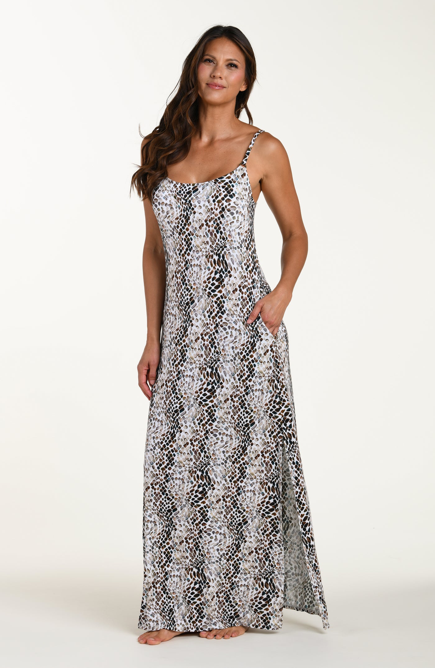 
                  
                    Full body front image of model wearing a sleeveless maxi cover-up dress with thin over the shoulder straps, pockets, and an allover taupe colored animal print.
                  
                