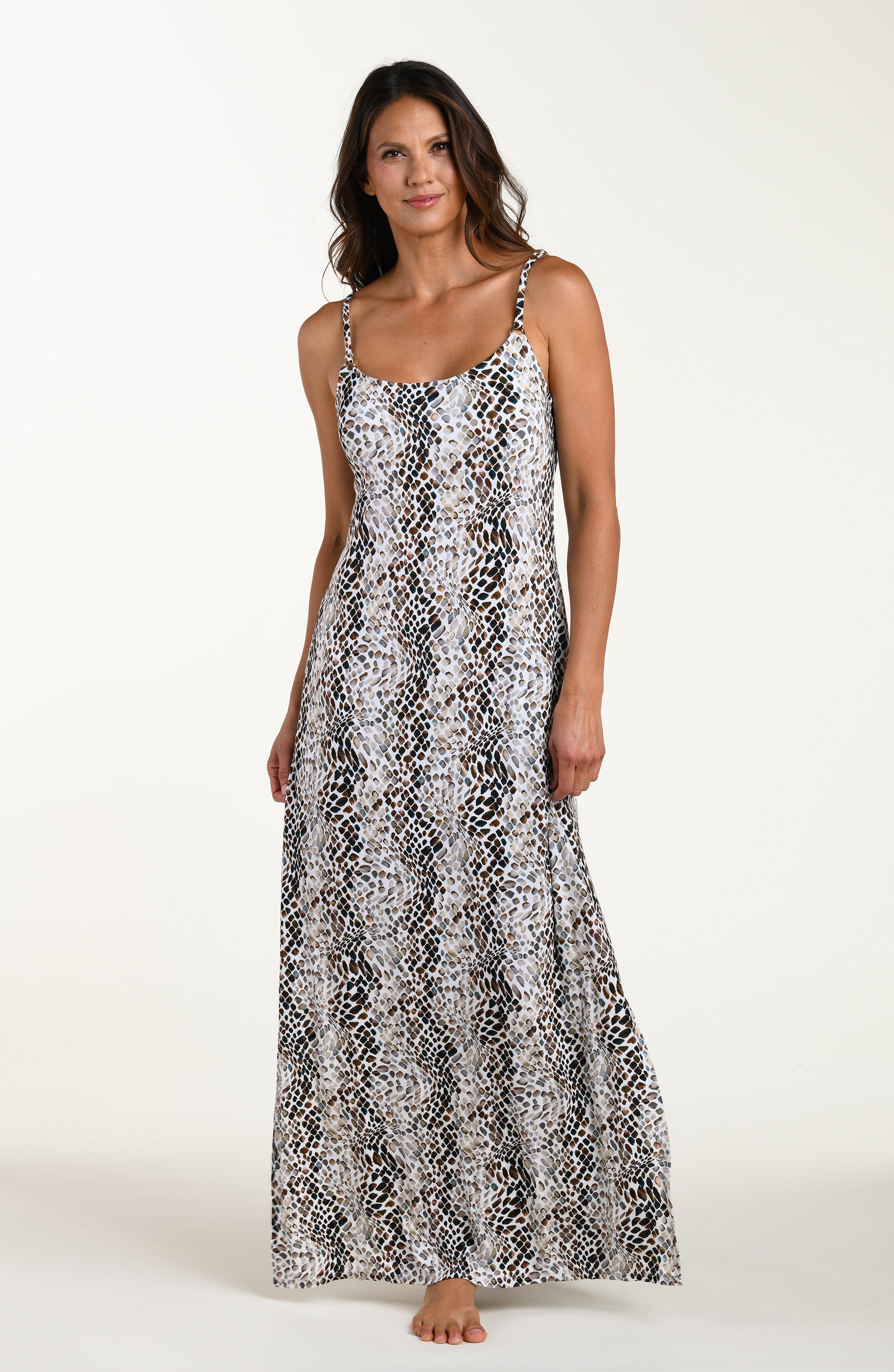 Full body front image of model wearing a sleeveless maxi cover-up dress with thin over the shoulder straps, pockets, and an allover taupe colored animal print.