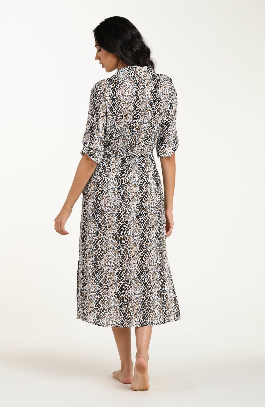 Full body back image of model wearing a midi-length cover-up dress featuring a taupe colored animal print with three-quarter sleeves, a V-neckline, and a waist tie belt.