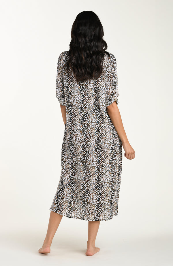 Full body back image of model wearing a midi-length cover-up dress featuring a taupe colored animal print with three-quarter sleeves, a V-neckline, and a waist tie belt.