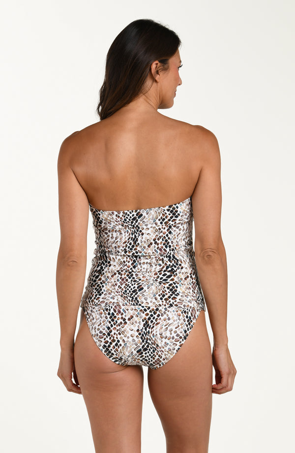 Back image of model wearing a bandeau-style one-piece swimsuit without the shoulder straps in a multicolor animal print pattern. This is paired with matching bikini bottoms.