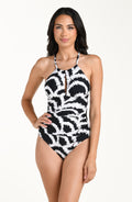 Front image of model wearing a black and white multicolored one piece swimsuit featuring a supportive, flattering fit with adjustable crisscross straps and a tie-back detail.