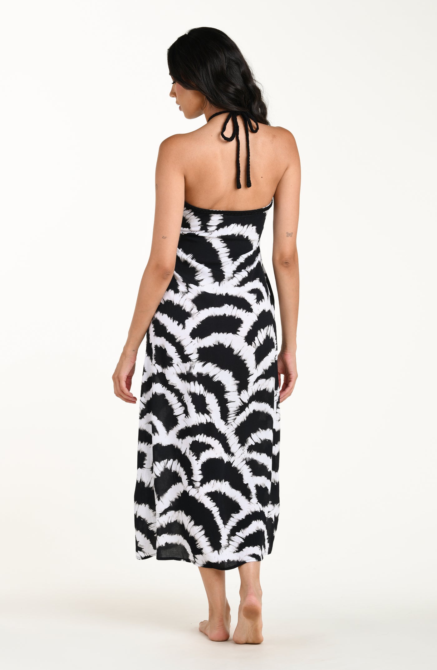 
                  
                    Full body back image of model wearing a black and white multicolored maxi dress cover-up featuring a loose, flowy fit with a halter neckline and lightweight fabric.
                  
                