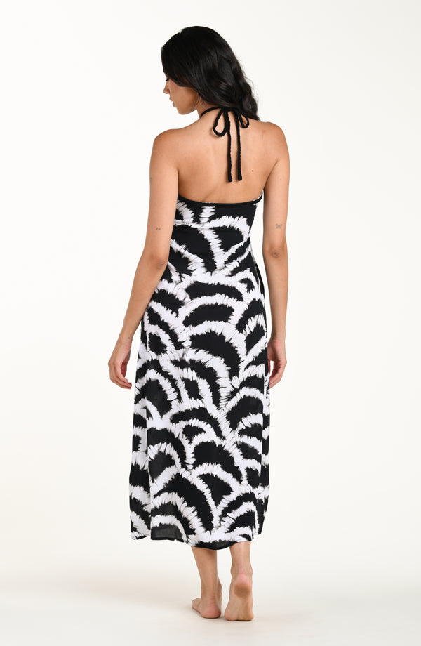 Full body back image of model wearing a black and white multicolored maxi dress cover-up featuring a loose, flowy fit with a halter neckline and lightweight fabric.