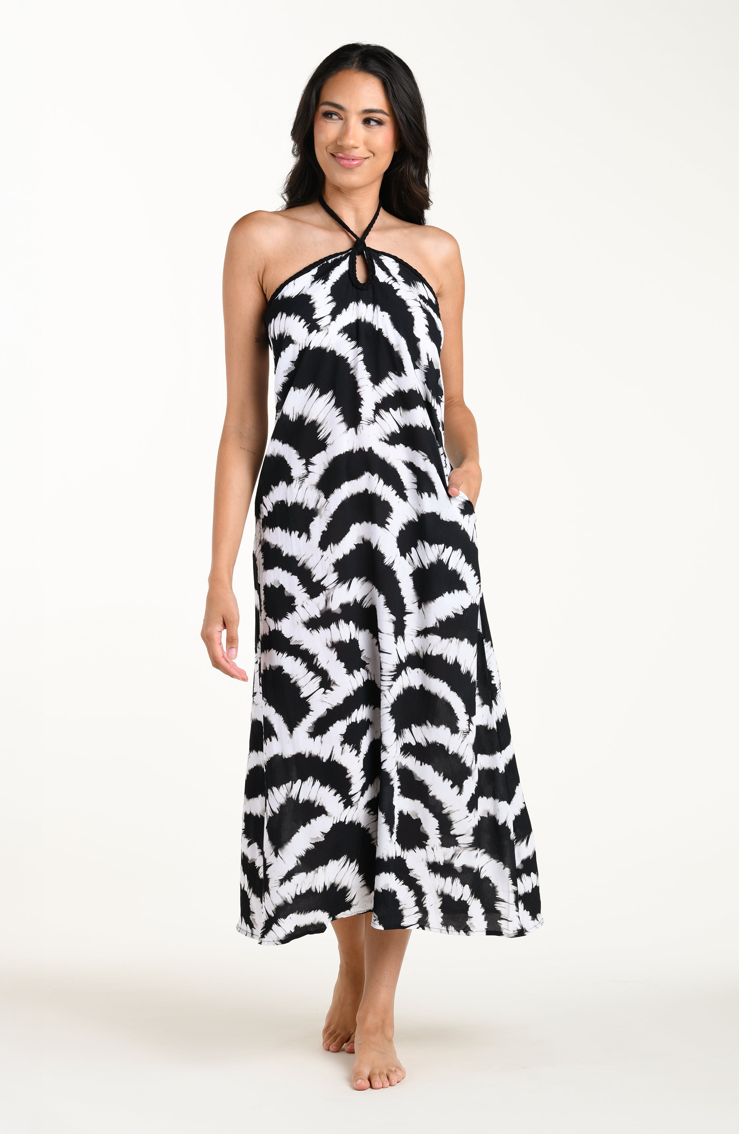 Full body front image of model wearing a black and white multicolored maxi dress cover-up featuring a loose, flowy fit with a halter neckline and lightweight fabric.