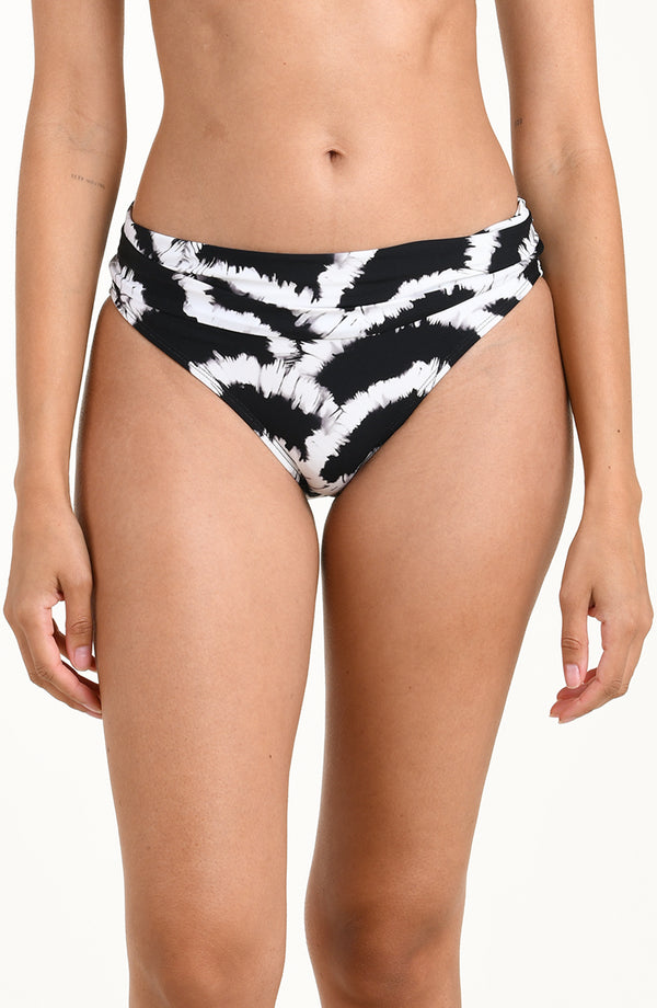 Front image of model wearing a black and white multicolored bikini bottom featuring a mid-rise fit with a fold-over waistband. 