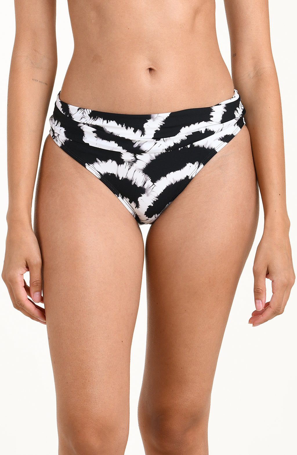 Front image of model wearing a black and white multicolored bikini bottom featuring a mid-rise fit with a fold-over waistband. 