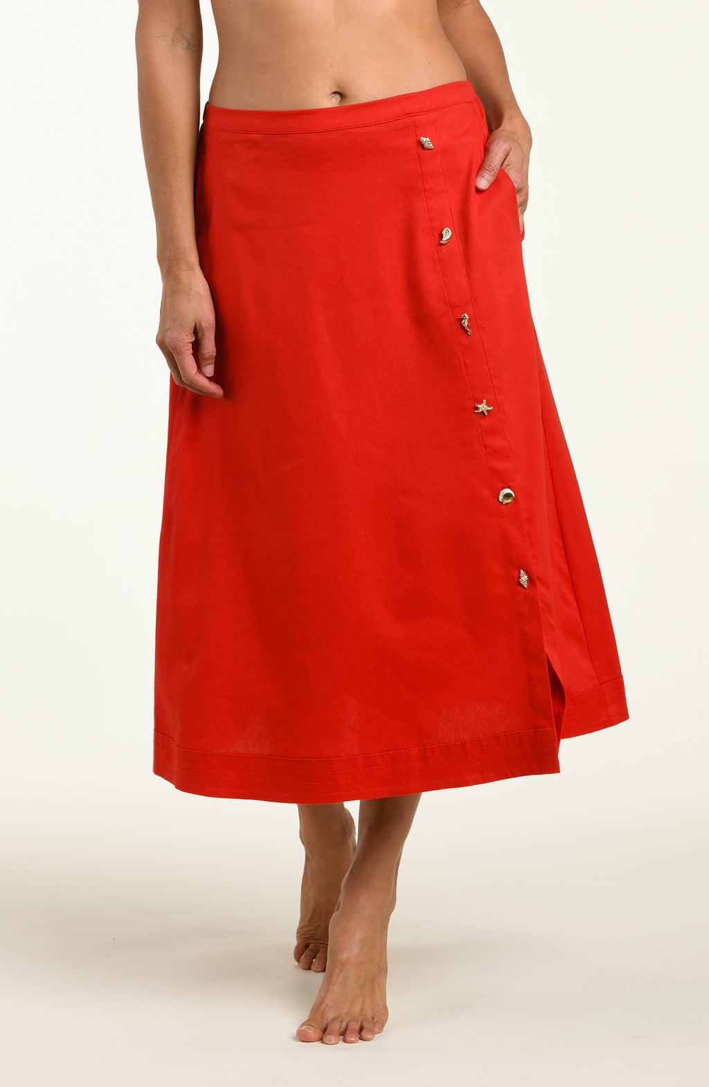 Woman wearing a red cover up skirt against a white background.