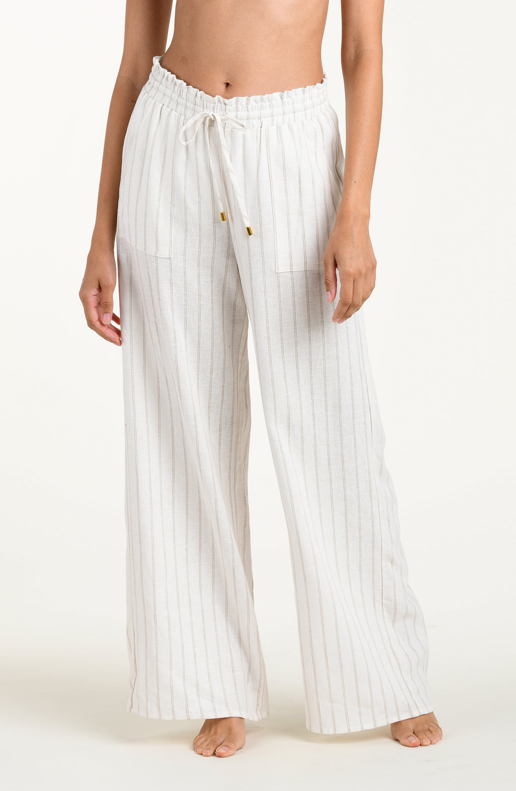 Front image of model wearing a cream striped colored wide-leg beach pants with a relaxed fit, drawstring waistband, and pockets.