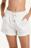 Front image of model wearing cream striped colored beach shorts with an elastic drawstring waistband, front pockets, and cuffed hems. 