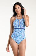 Woman wearing a blue patterned one piece swimsuit against a white background