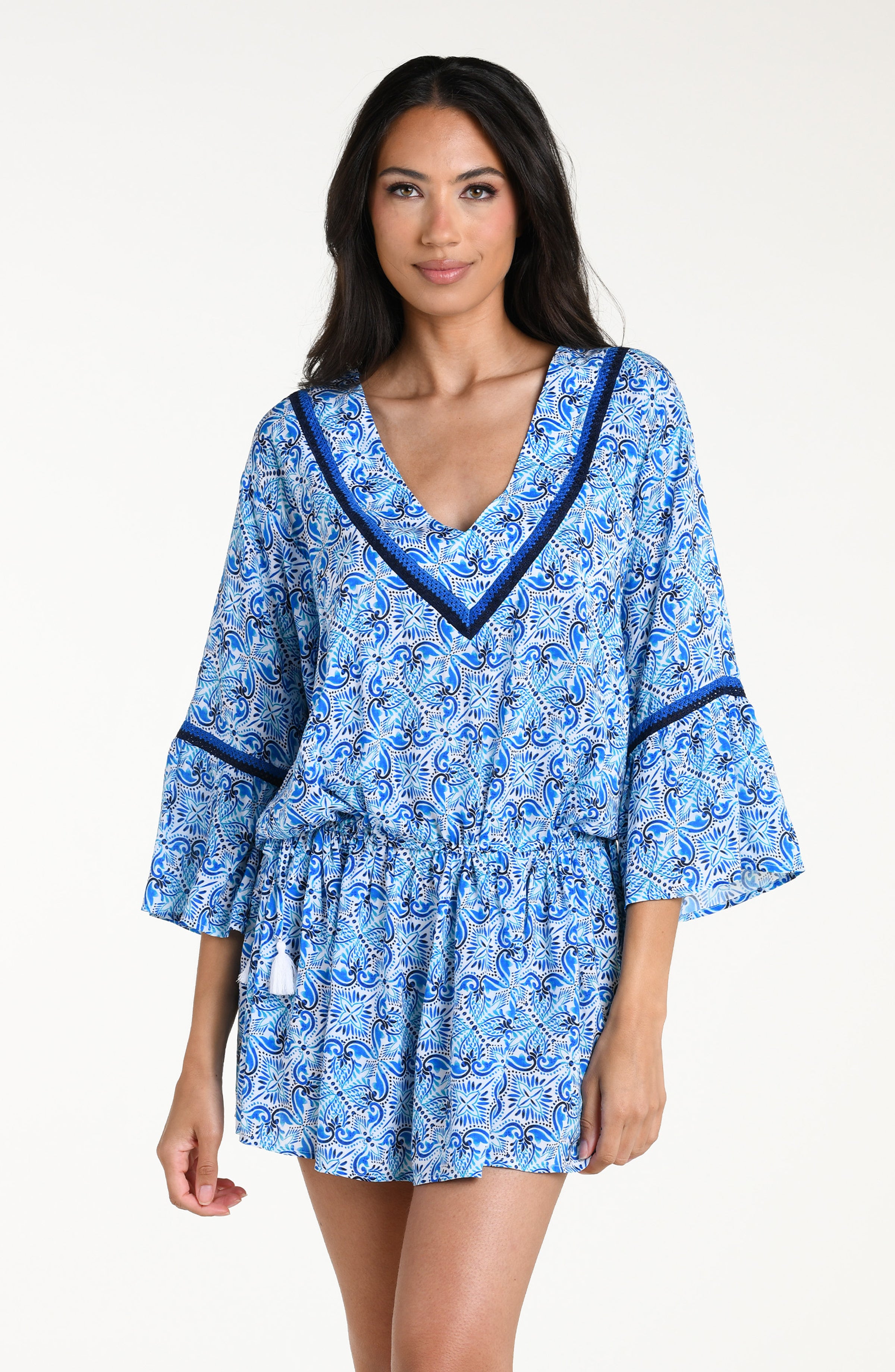 Woman wearing a blue floral patterned  V-neck tunic cover up against a white background