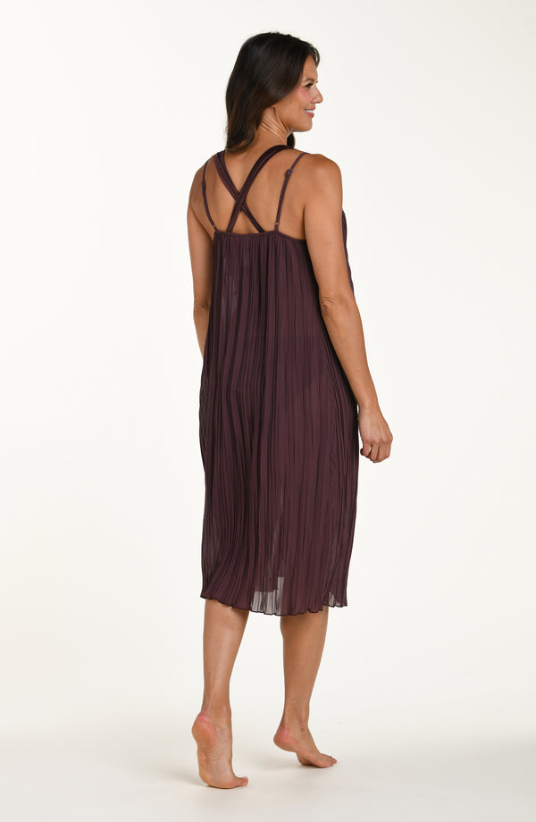 Woman wearing a dark purple slip dress on a white background
