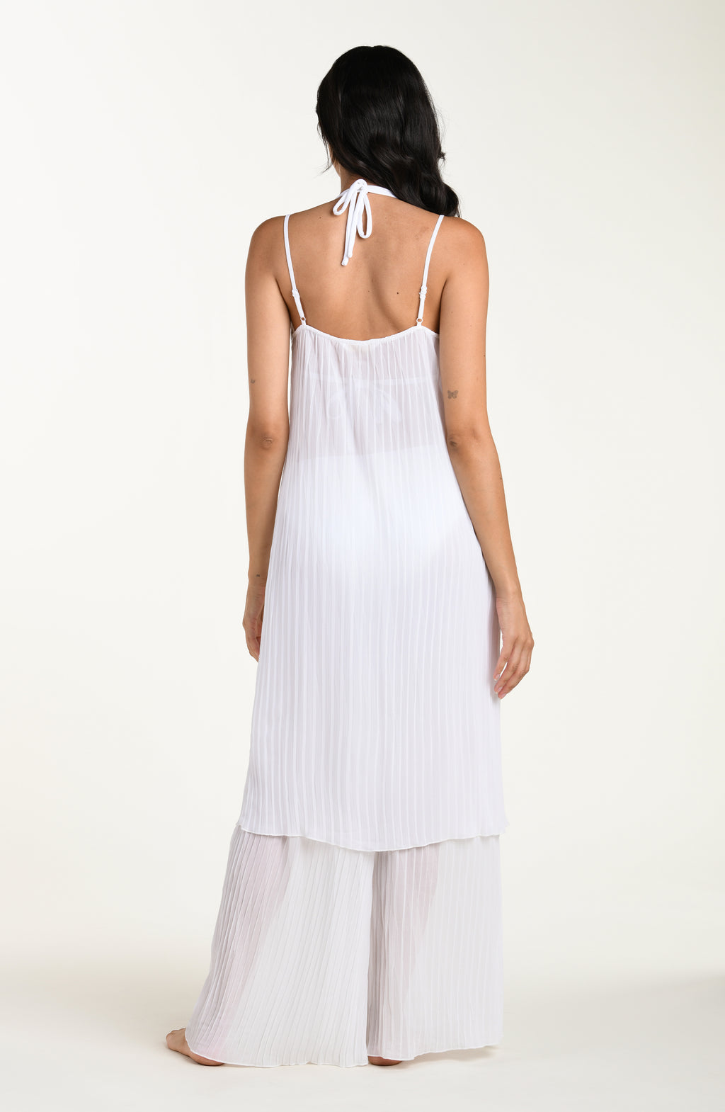 Woman wearing a white dress with thin straps on a white background