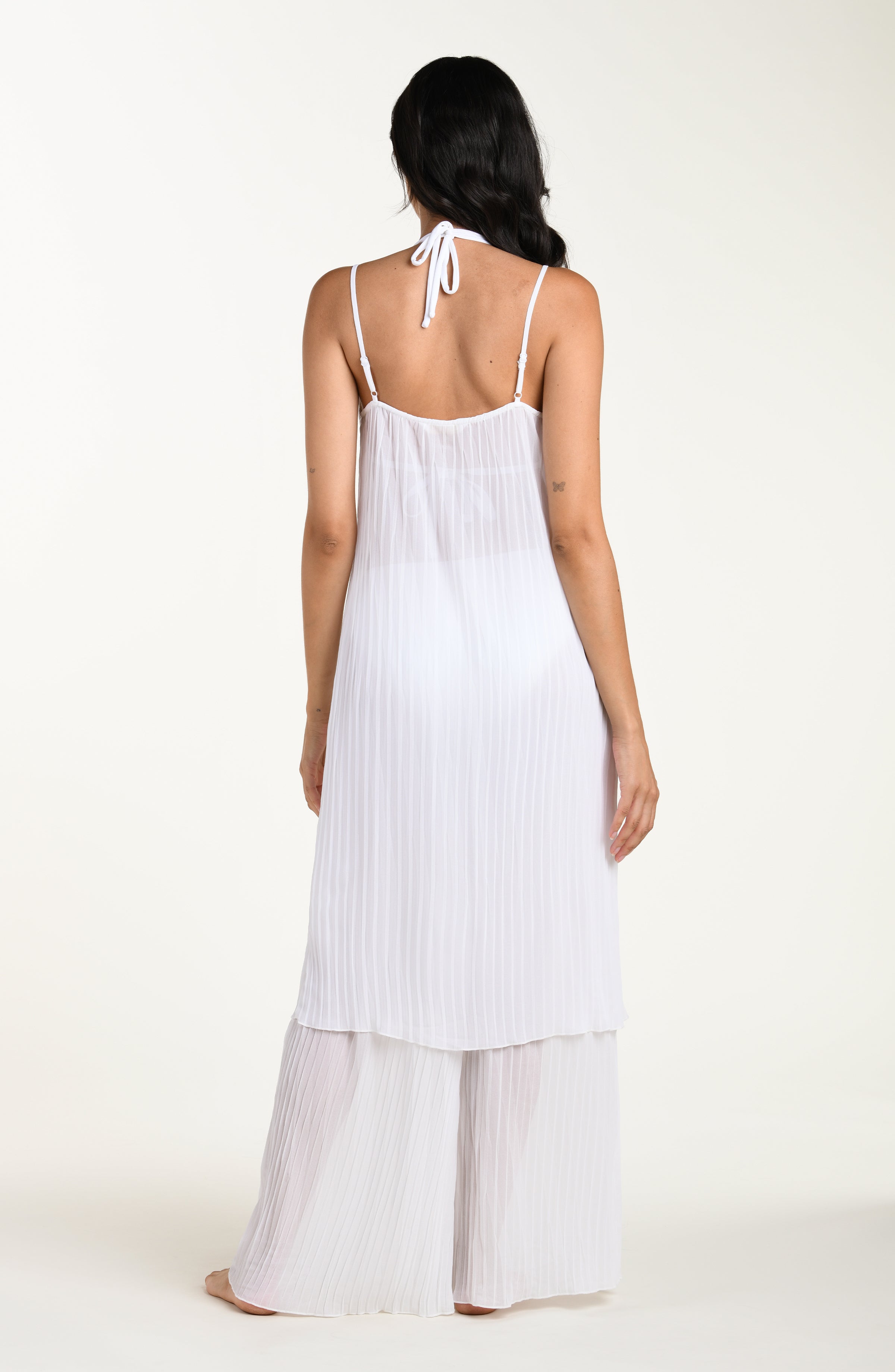 Woman wearing a white dress with thin straps on a white background