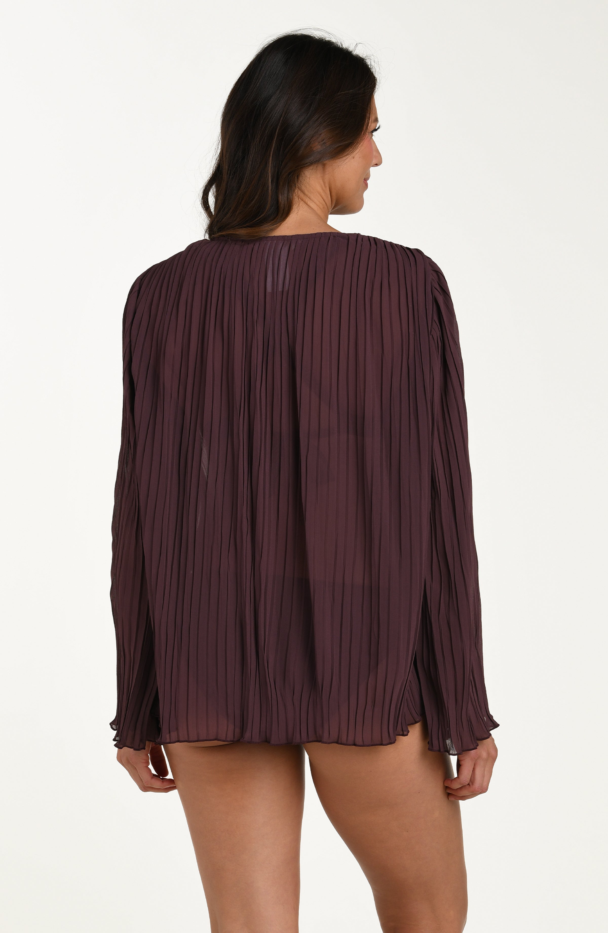 Woman wearing a pleated burgundy blouse on a white background