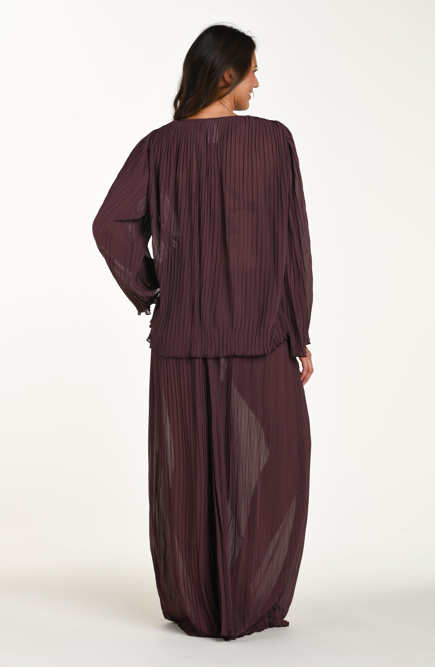 
                  
                    Woman wearing a long burgundy dress with sheer overlay on a white background
                  
                