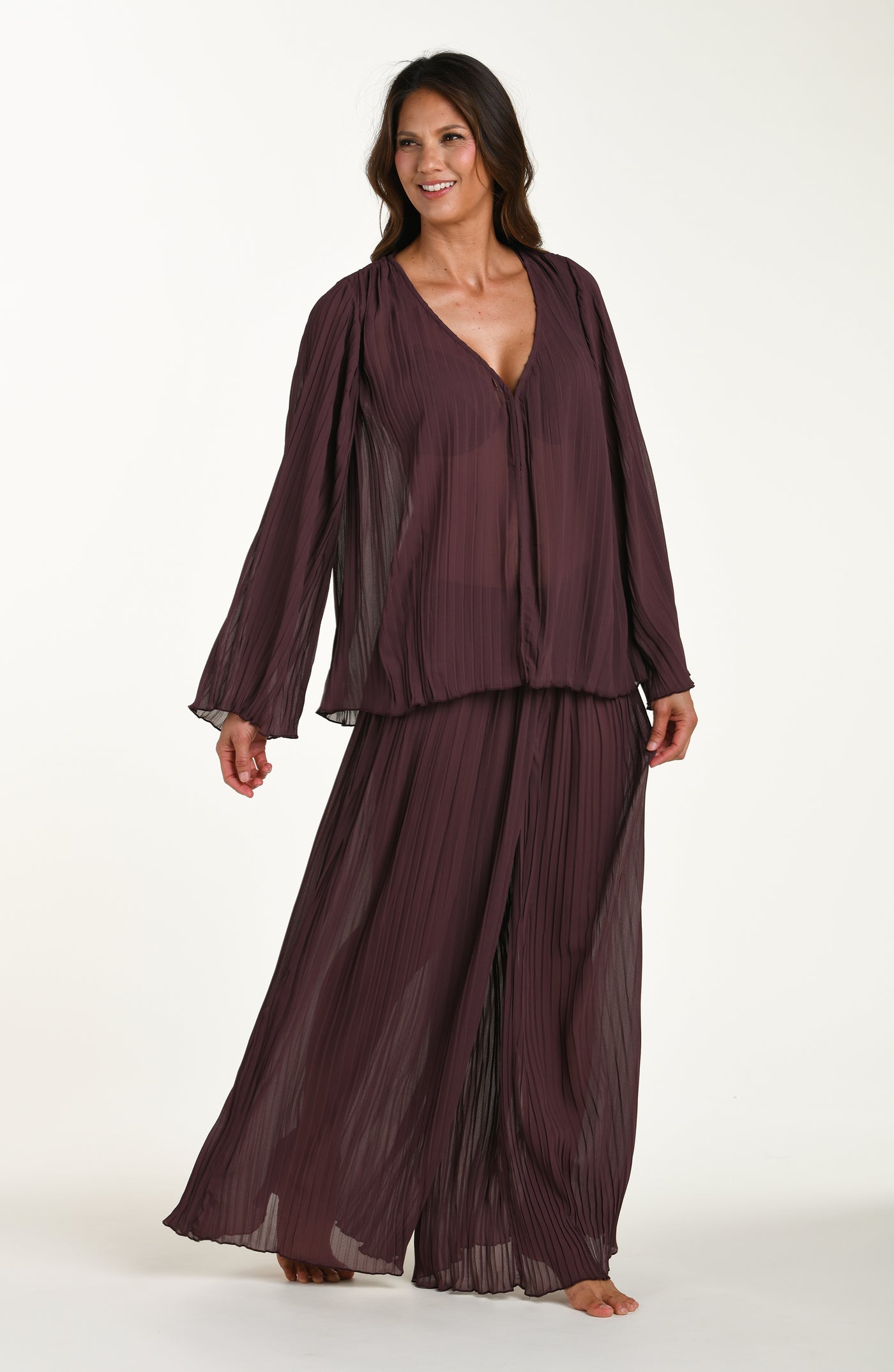 
                  
                    Woman wearing a dark brown outfit on a white background
                  
                