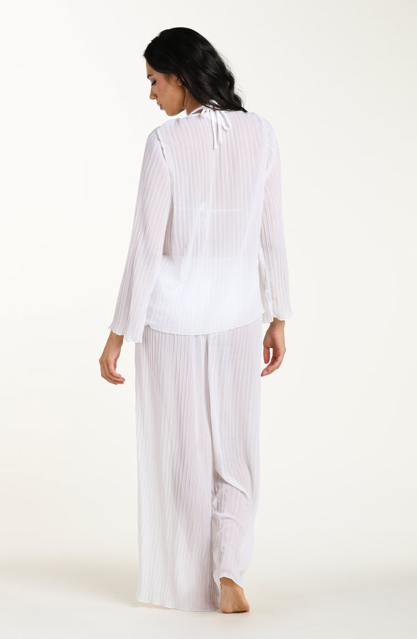 Woman wearing a white striped shirt and wide-leg pants on a white background