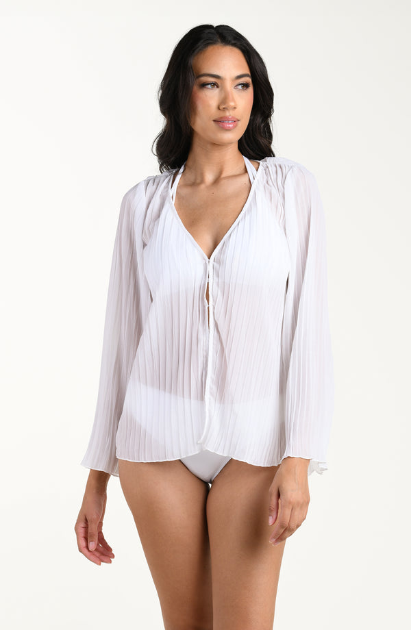 Woman wearing a white sheer blouse over a white bikini on a white background