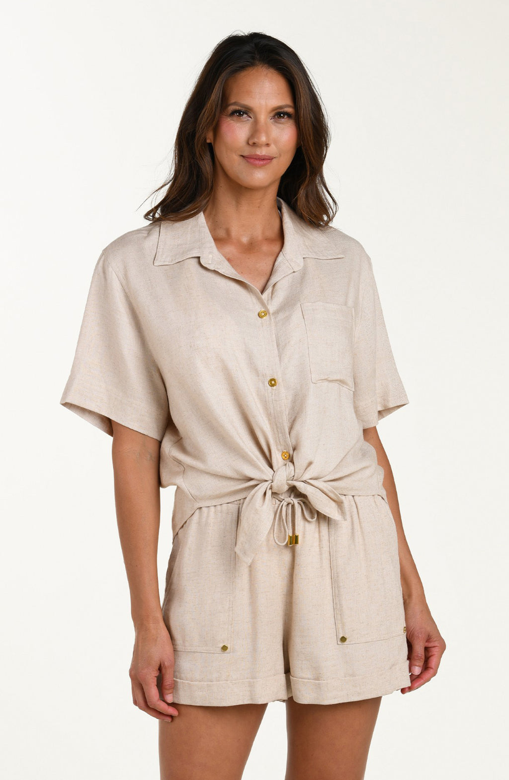 Front image of model wearing a taupe colored short-sleeve cover-up shirt with button front, chest pocket, and tie-front waist. It's paired with matching beach shorts.
