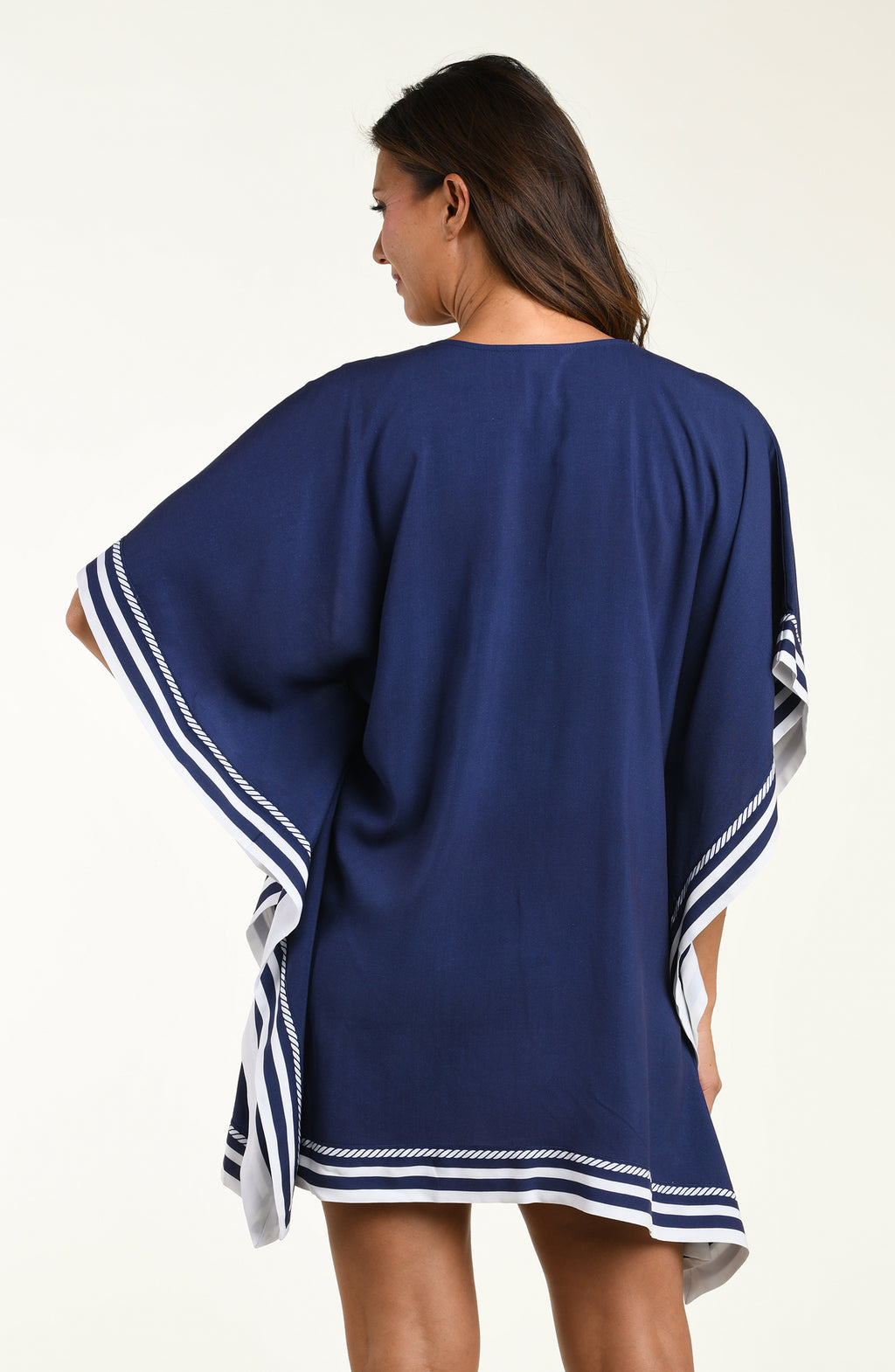 Woman wearing a navy blue tunic cover up with white floral patterns on a white background