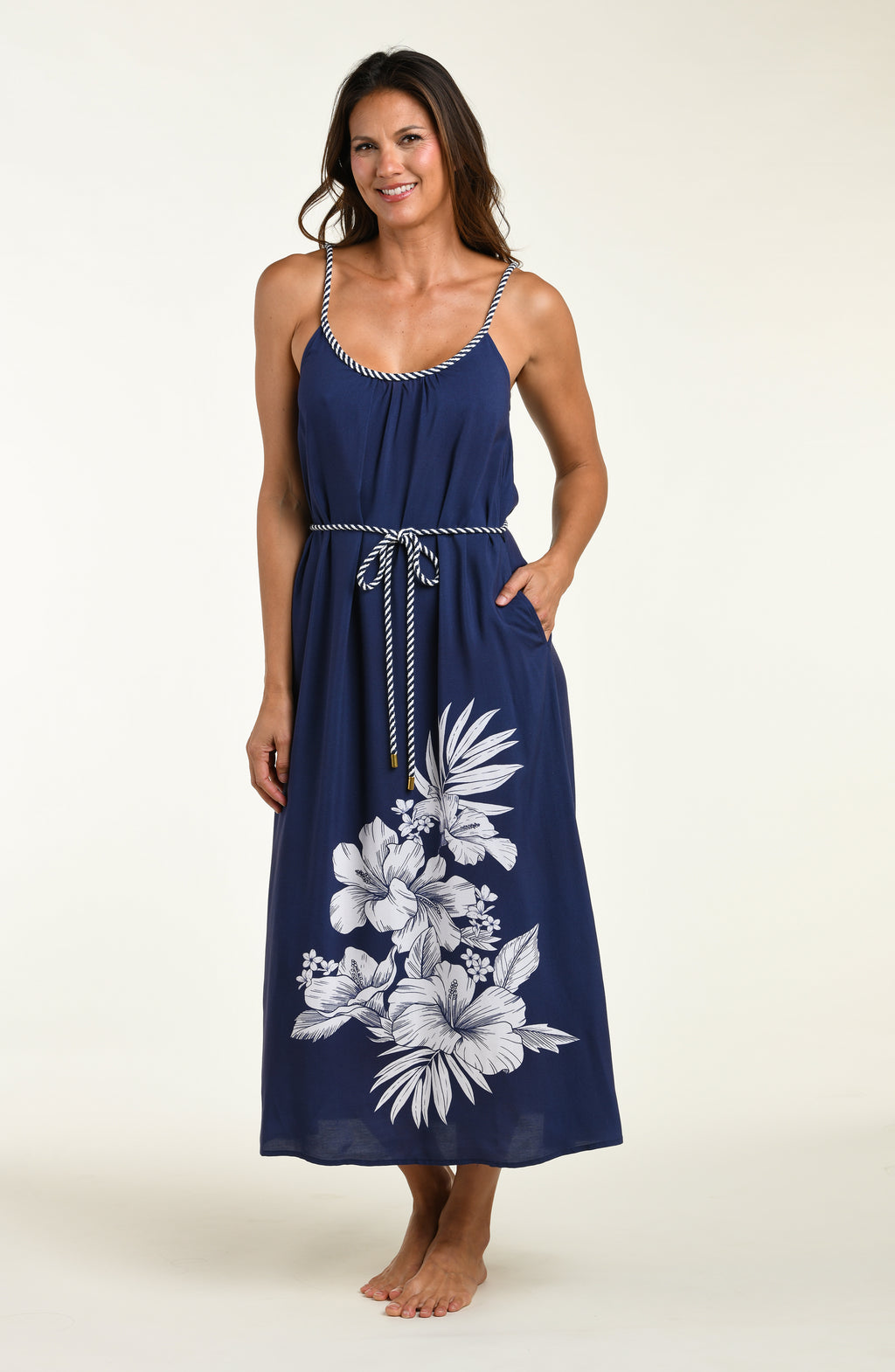 Woman wearing a navy blue cover up dress with floral patterns on a white background