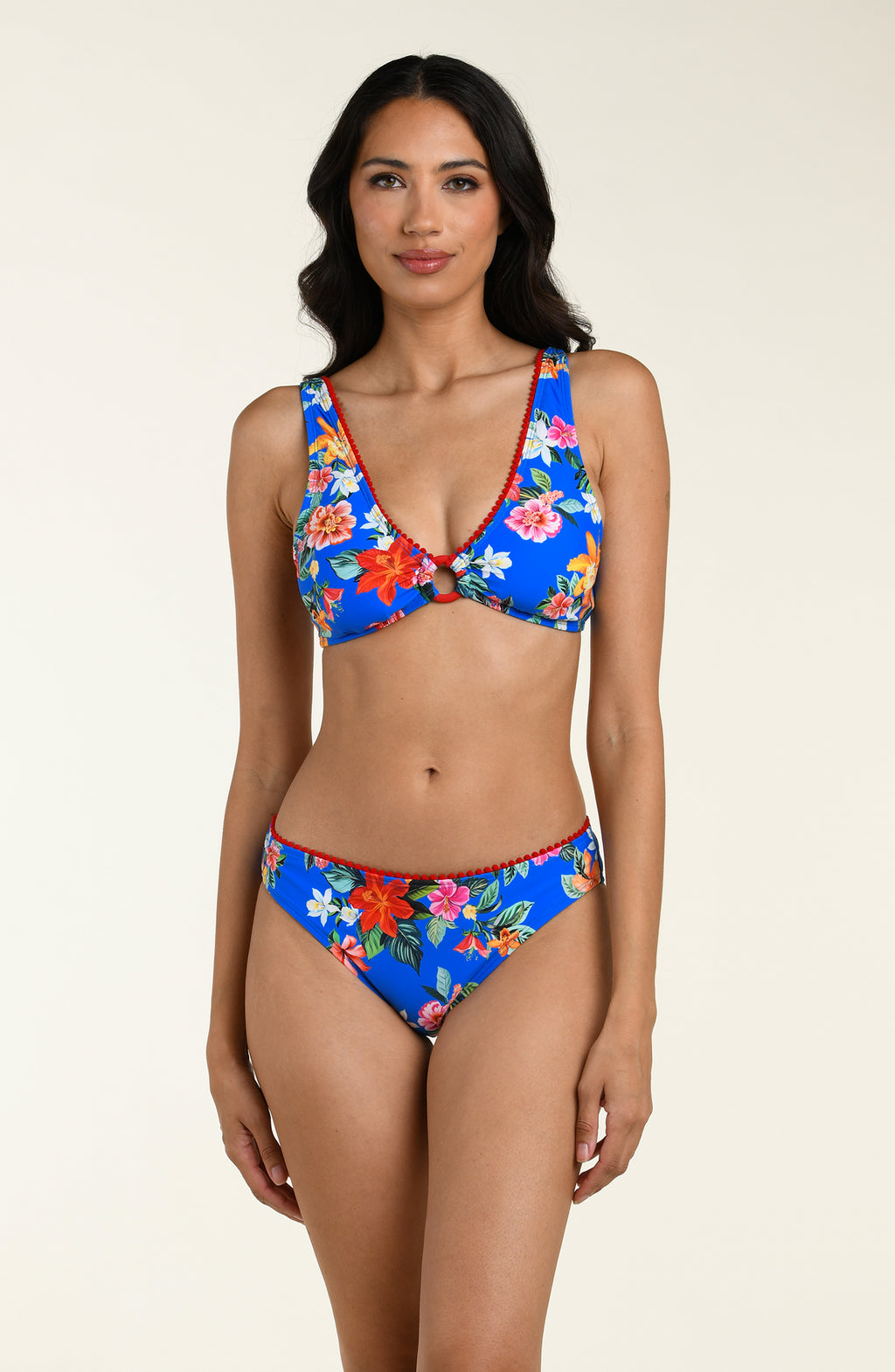 Woman wearing a blue floral bikini top and matching bottom on a beige background