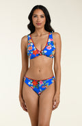 Woman wearing a blue floral bikini top and matching bottom on a beige background