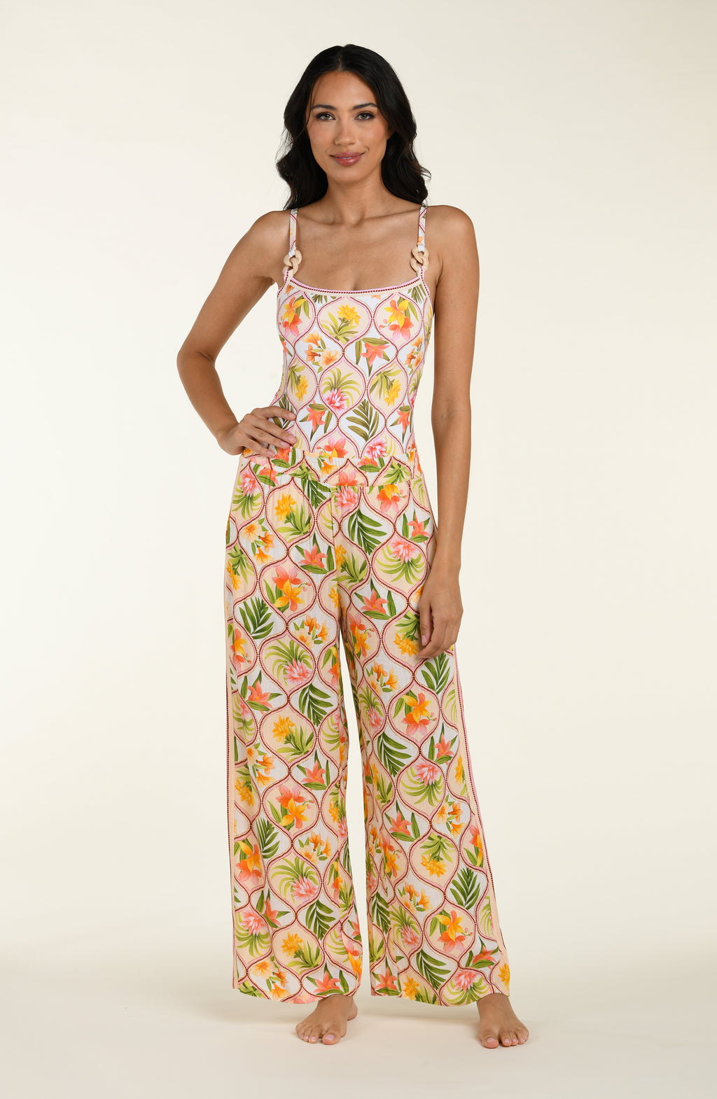 Floral patterned pants and matching top worn by a person on a white background