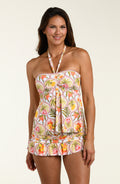 Woman wearing a floral halter tankini top and a matching swim skirt with a white background