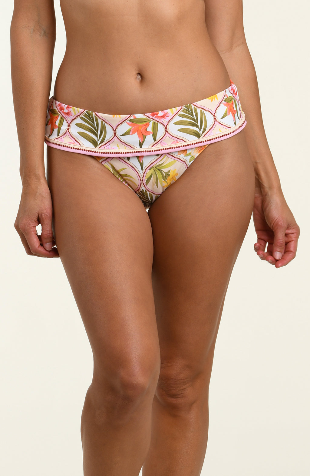 Woman wearing a floral printed bikini bottom against a white background.