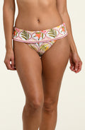 Woman wearing a floral printed bikini bottom against a white background.