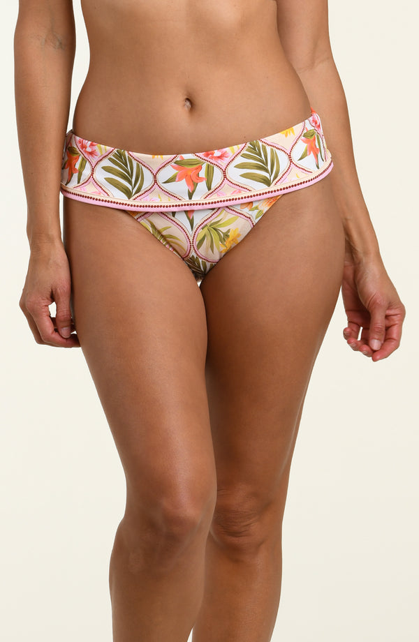 Woman wearing a floral printed bikini bottom against a white background.