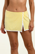 Yellow patterned swim skirt worn by a person on a beige background