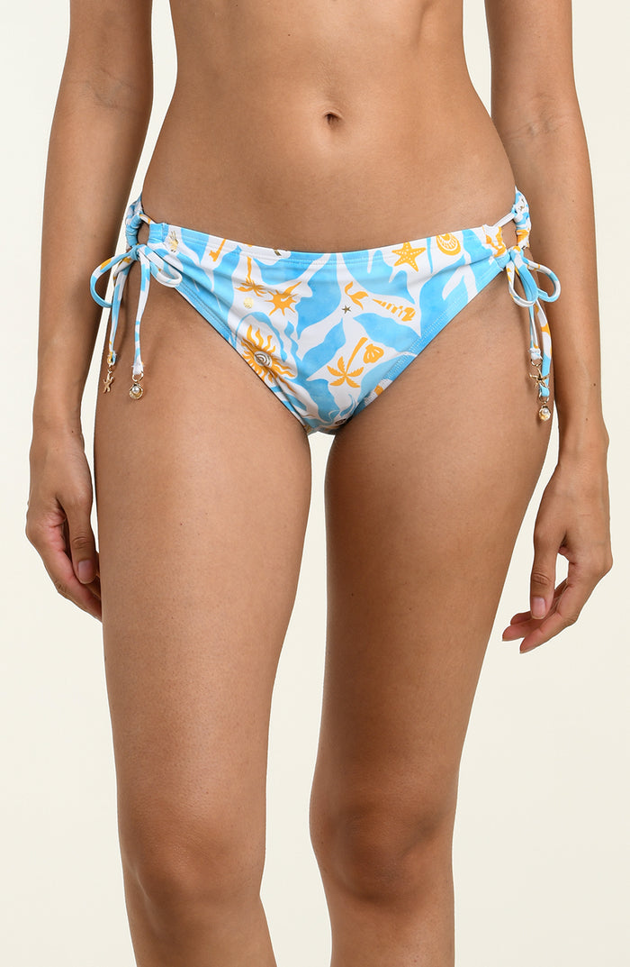 Woman wearing a multicolored blue and white bikini bottom against a white background. 