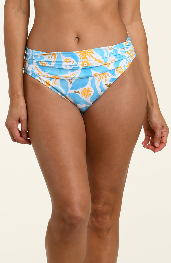 Woman wearing a multicolored blue and white bikini bottom against a white background. 
