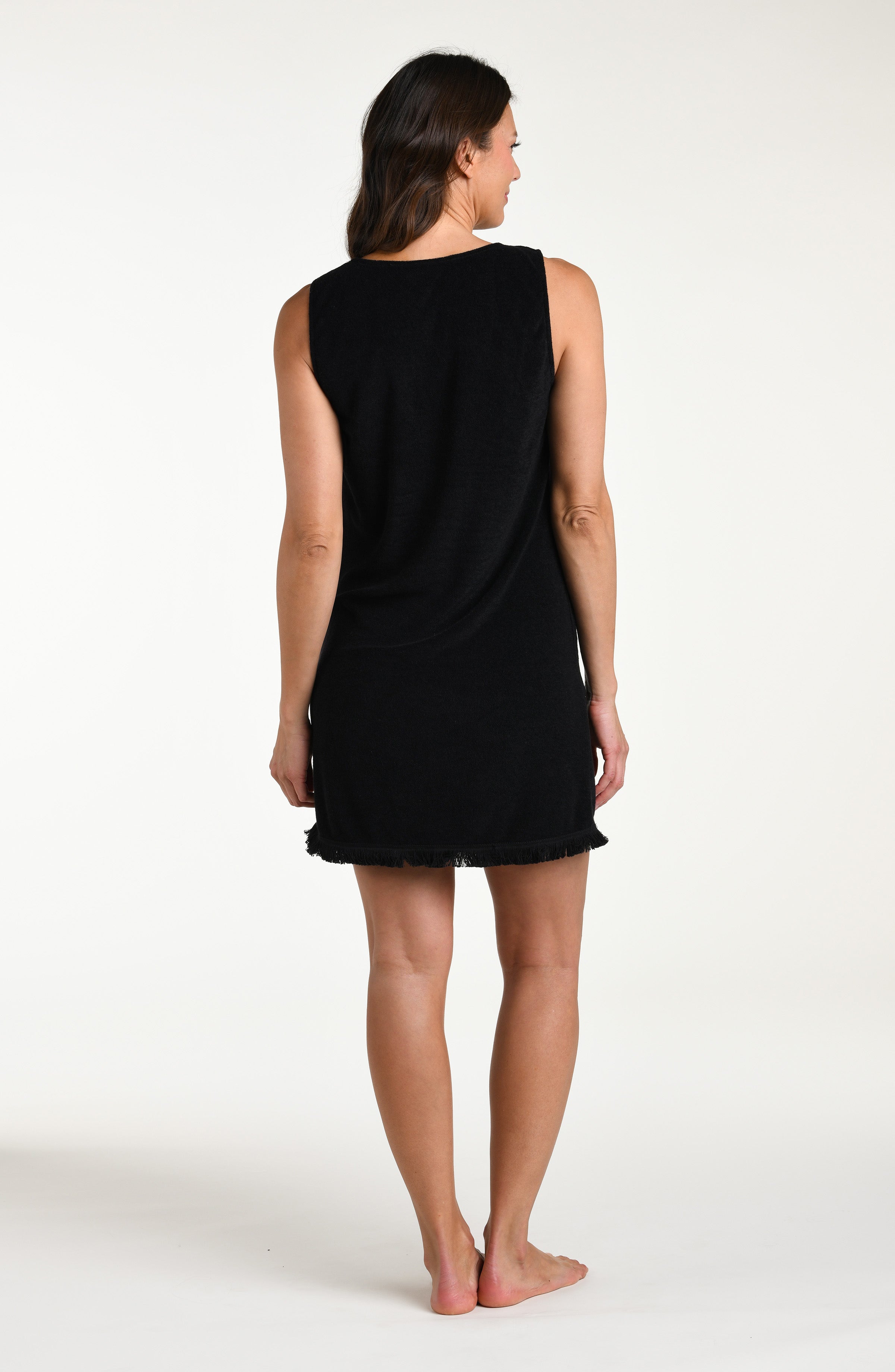 Woman wearing a black mini cover up dress against a white background