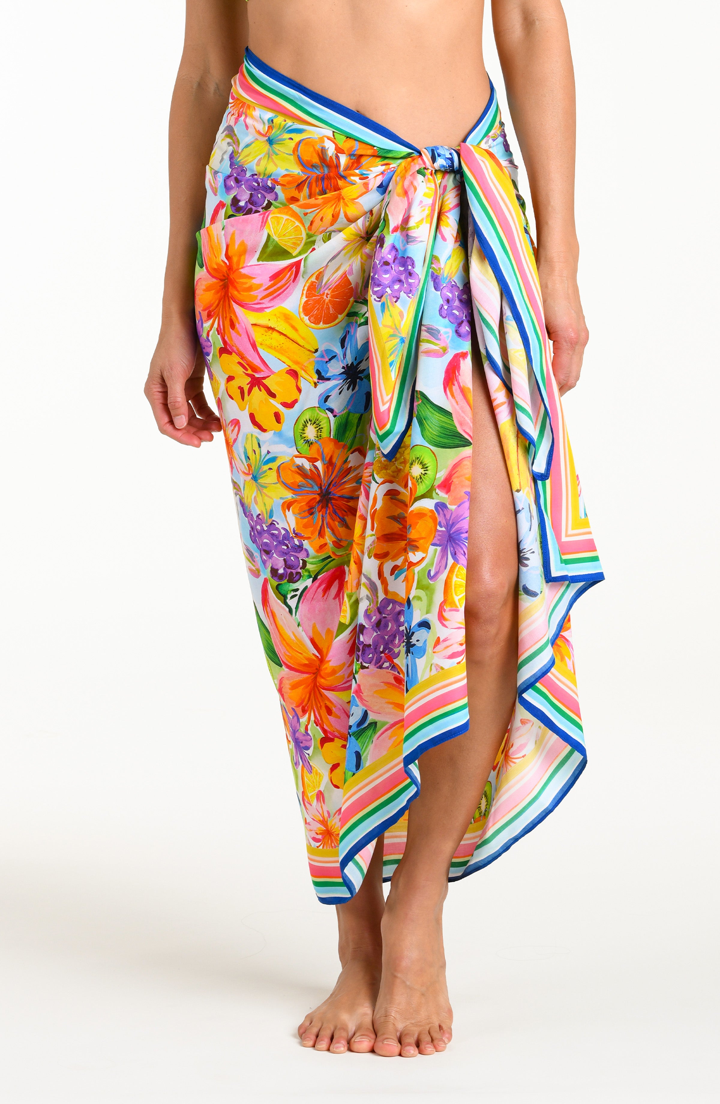 Woman wearing a colorful tropical pareo wrap against a white background.