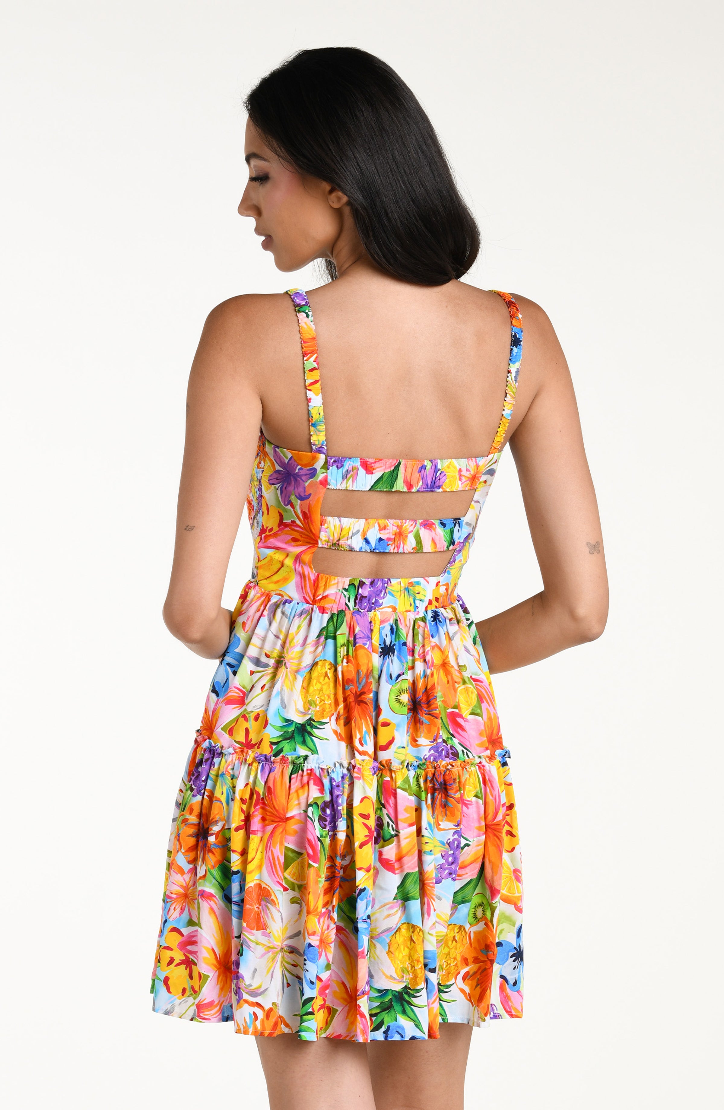Woman wearing a colorful floral mini dress cover up against a white background
