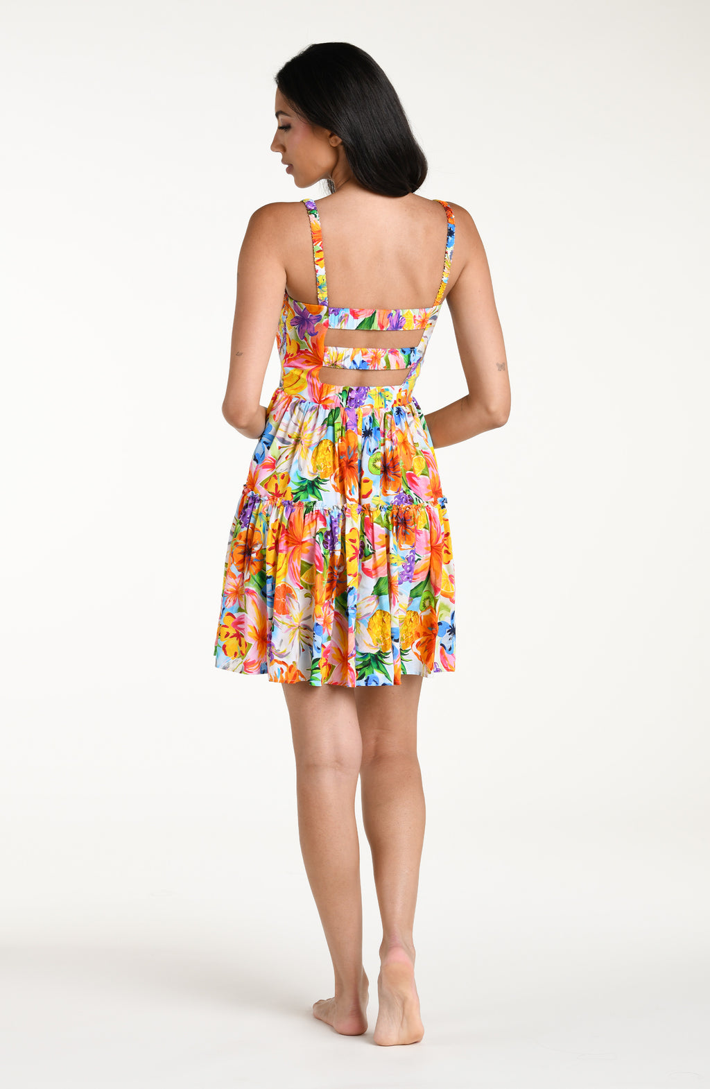 Woman wearing a colorful floral mini dress cover up against a white background