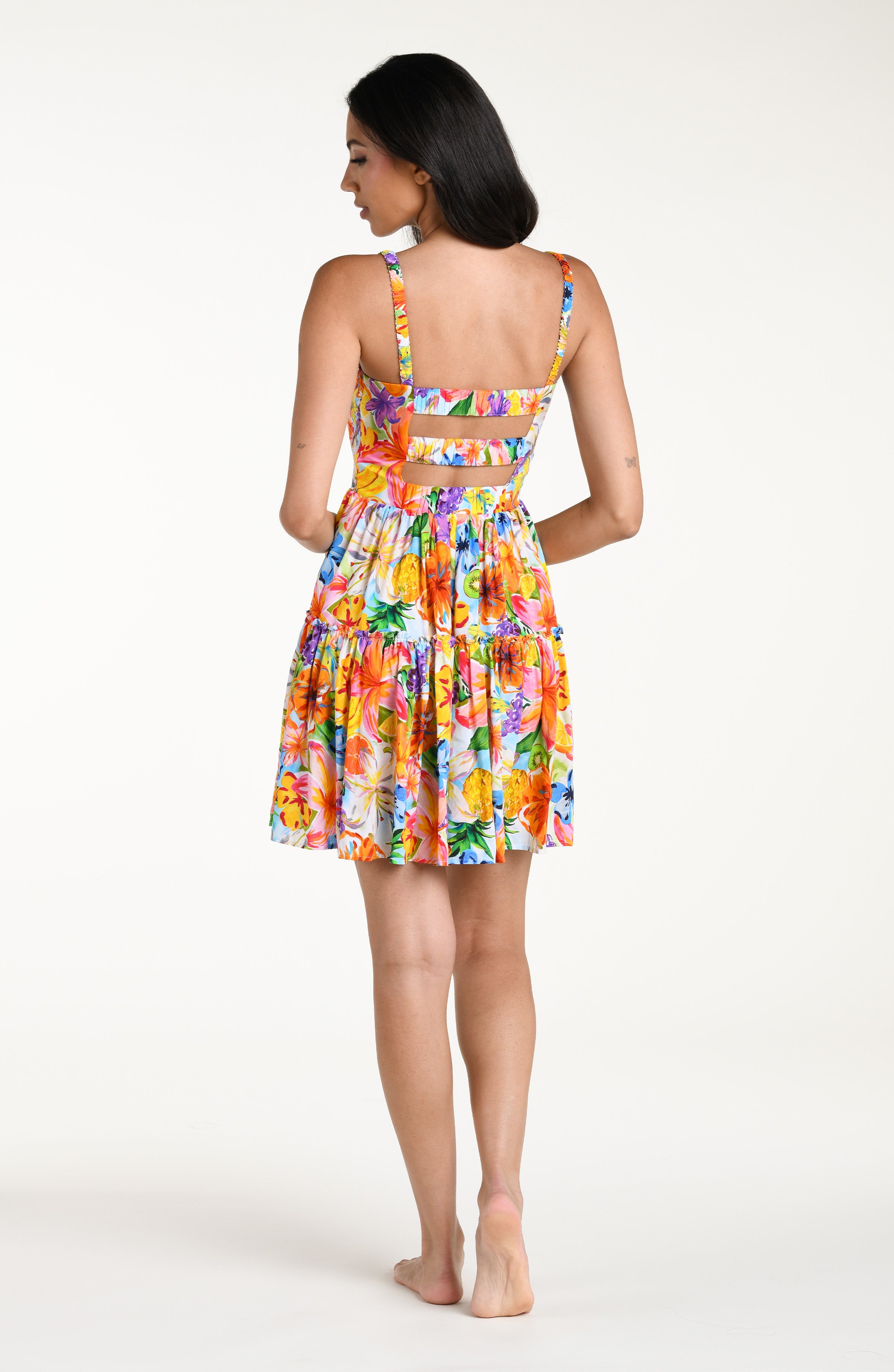 Woman wearing a colorful floral mini dress cover up against a white background