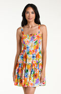 Woman wearing a colorful floral mini dress cover up against a white background