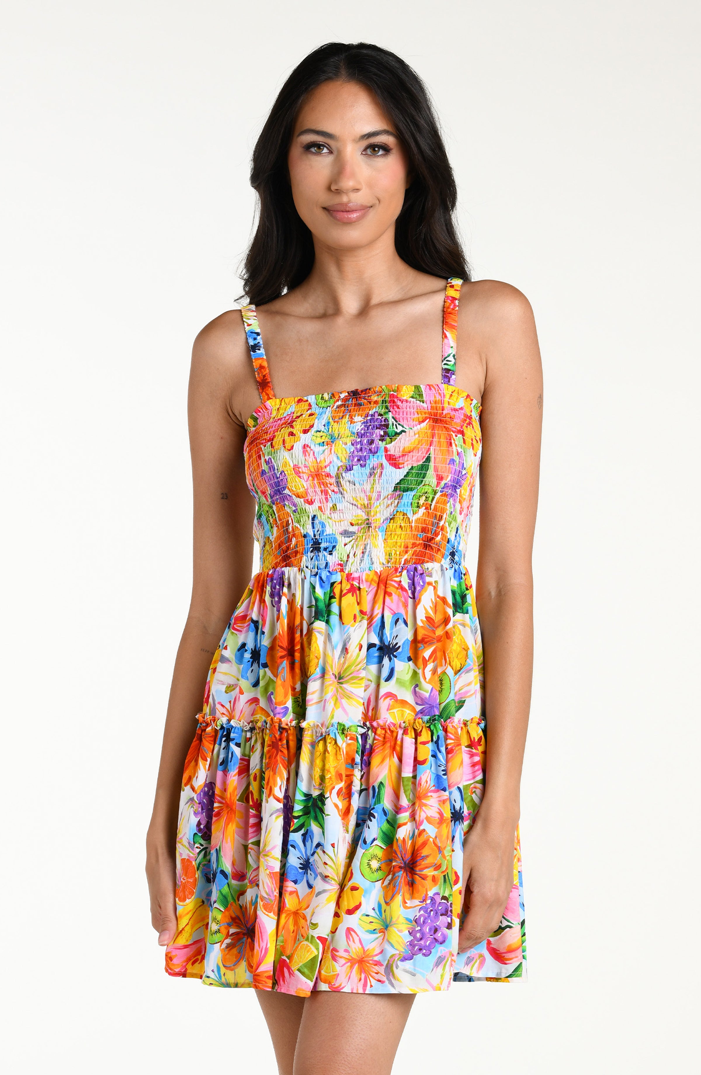 Woman wearing a colorful floral mini dress cover up against a white background